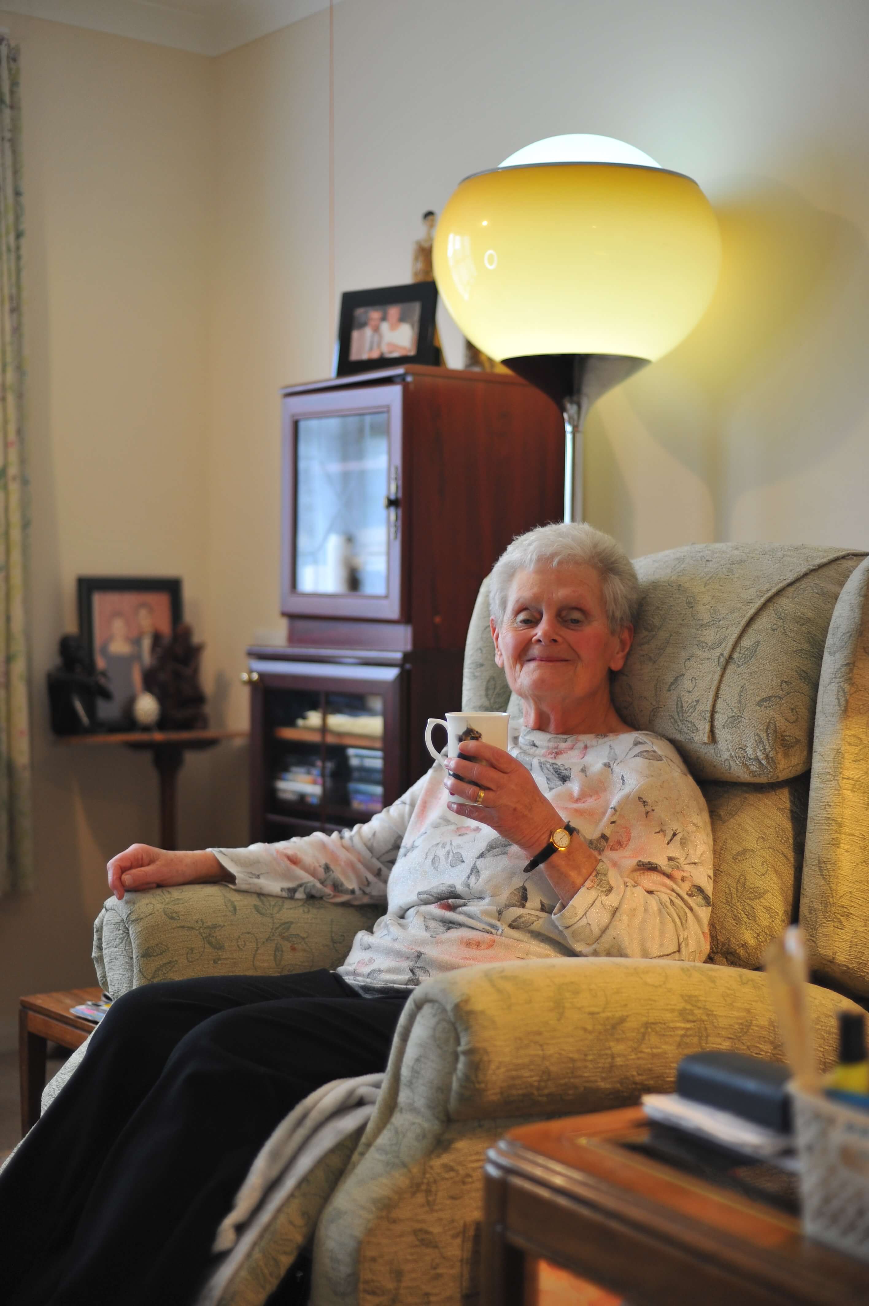 Elderly lady sat on coach at home